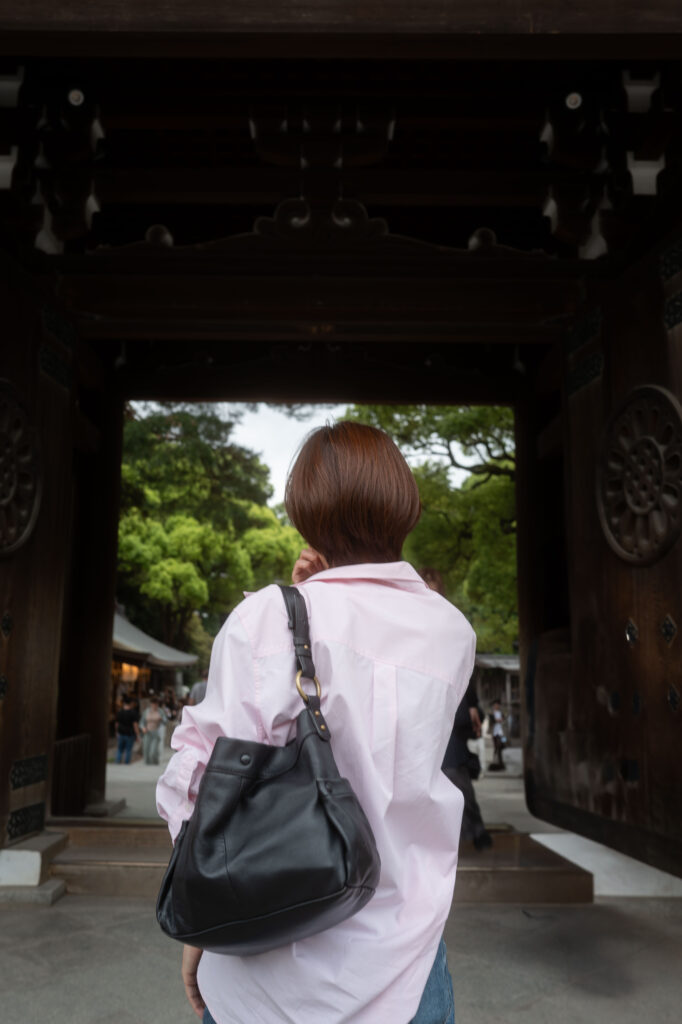 Roter Torii-Bogen vor einem traditionellen Shinto-Schrein in Japan, umgeben von Bäumen und Ruhe
