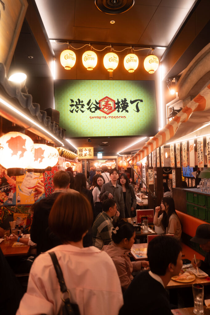 Menschenmengen bei Nacht am Shibuya Crossing in Tokyo mit Neonlichtern und urbanem Flair